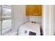 Bright laundry room features a washing machine and cabinet storage above at 6825 Woodleaf Rd, Woodleaf, NC 27054