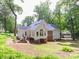 Backyard view of the home with a patio, furniture, landscaping and mature trees at 6934 Loretta Pl, Charlotte, NC 28215