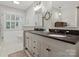 Bathroom with a dual sink vanity, black countertop, decorative mirrors and fixtures, and tiled floor at 6934 Loretta Pl, Charlotte, NC 28215