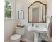 Charming half bathroom with a pedestal sink and decorative mirror at 6934 Loretta Pl, Charlotte, NC 28215