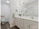 Bathroom featuring a dual sink vanity, white cabinets, and a toilet with hardwood-style flooring at 6934 Loretta Pl, Charlotte, NC 28215
