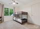 Cozy bedroom featuring bunk beds, a window with natural light, and neutral-toned carpet at 6934 Loretta Pl, Charlotte, NC 28215