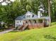 Charming white home with inviting front porch, brick accents, and lush greenery at 6934 Loretta Pl, Charlotte, NC 28215