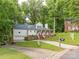 Charming two-story home with a welcoming front porch and well-maintained landscaping in a lush, green neighborhood at 6934 Loretta Pl, Charlotte, NC 28215