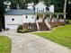 Charming two-story home with a welcoming front porch and well-maintained landscaping in a lush, green neighborhood at 6934 Loretta Pl, Charlotte, NC 28215