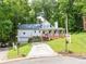 Charming two-story home with a welcoming front porch and well-maintained landscaping in a lush, green neighborhood at 6934 Loretta Pl, Charlotte, NC 28215