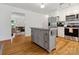 Bright open kitchen with an island, hardwood floors and stainless steel appliances at 6934 Loretta Pl, Charlotte, NC 28215
