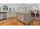 Bright kitchen featuring a farmhouse sink, wooden floors and a kitchen island perfect for food prep at 6934 Loretta Pl, Charlotte, NC 28215
