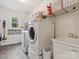 Bright laundry room with washer, dryer, sink, and plenty of shelving and storage at 6934 Loretta Pl, Charlotte, NC 28215