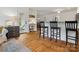 Open living area with hardwood floors, built-in desk, and breakfast bar seating at 6934 Loretta Pl, Charlotte, NC 28215
