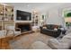 Bright living room featuring a brick fireplace, custom bookshelves, and large windows at 6934 Loretta Pl, Charlotte, NC 28215