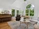 Sunlit living room featuring a piano, large arched window, and hardwood floors at 6934 Loretta Pl, Charlotte, NC 28215