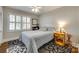 Comfortable bedroom with natural light, grey walls, hardwood floors and vintage rug at 7026 Tabor Ln, Charlotte, NC 28211