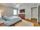 Cozy bedroom featuring hardwood floors, modern ceiling fan and a mounted flatscreen television at 7026 Tabor Ln, Charlotte, NC 28211