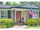 Inviting front entrance with a red door, decorative ironwork, and an American flag waving in the breeze at 7026 Tabor Ln, Charlotte, NC 28211