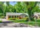 Lovely brick home with green shutters, an American flag, and a lush front yard with mature trees at 7026 Tabor Ln, Charlotte, NC 28211
