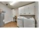 Functional laundry room with storage cabinets, folding table, and modern washer and dryer at 7026 Tabor Ln, Charlotte, NC 28211