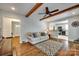Comfortable living room showcasing wood floors, a modern rug, and seamless kitchen access at 7026 Tabor Ln, Charlotte, NC 28211