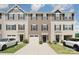 View of townhome exteriors with garages, well-kept lawns and dark shutters at 706 Dillon Way, Fort Mill, SC 29715