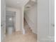 Hallway view featuring tiled flooring, a staircase with carpeted steps, and neutrally painted walls at 706 Dillon Way, Fort Mill, SC 29715