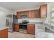Kitchen with granite countertops, tile backsplash, stainless steel appliances, and brown cabinetry at 706 Dillon Way, Fort Mill, SC 29715