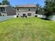 Large, flat backyard features a lush lawn, wood fence, a grill, and patio set at 712 Harrier Rd, Charlotte, NC 28216