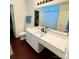 Bright bathroom featuring a modern vanity with white countertops and dark wood floors at 712 Harrier Rd, Charlotte, NC 28216