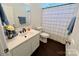 Cozy bathroom with white vanity, modern fixtures, and a neutral-toned shower curtain at 712 Harrier Rd, Charlotte, NC 28216
