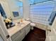 Clean bathroom features a white vanity, neutral walls, dark floors, and shower with tub at 712 Harrier Rd, Charlotte, NC 28216