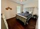 Bedroom with wood floor, a ceiling fan, a window and bed with black-and-white comforter at 712 Harrier Rd, Charlotte, NC 28216