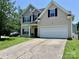 Traditional home with a two-car garage, a well-kept lawn, and a concrete driveway at 712 Harrier Rd, Charlotte, NC 28216