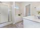 Bright bathroom featuring a shower, garden tub and single vanity at 7344 Gilead Rd, Huntersville, NC 28078
