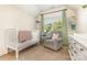 Cozy Bedroom with a crib, gray chair, and soft green accents creating a calm space at 7344 Gilead Rd, Huntersville, NC 28078