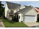 Exterior home view with a two-car garage, a small back deck, and a well-kept lawn at 7344 Gilead Rd, Huntersville, NC 28078