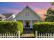 Charming yellow home featuring a gabled roof, inviting front porch with white columns and beautiful landscaping at 7344 Gilead Rd, Huntersville, NC 28078
