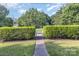 Manicured front yard with green lawn, hedge border and stone pathway leading to the inviting home at 7344 Gilead Rd, Huntersville, NC 28078