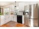 Bright kitchen with stainless steel refrigerator, black dishwasher, and ample cabinet space at 7344 Gilead Rd, Huntersville, NC 28078