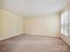 Bright, carpeted bedroom featuring a neutral color scheme and a window with sheer curtains for soft, natural light at 7639 Winterset Dr, Charlotte, NC 28270