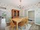 Classic dining room with wood flooring, floral wallpaper, and a wooden china cabinet, adjacent to open doorways at 7639 Winterset Dr, Charlotte, NC 28270