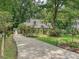 Charming home featuring a welcoming orange front door, a long driveway, and beautiful landscaping at 7639 Winterset Dr, Charlotte, NC 28270