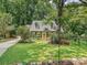 Inviting front exterior with green grass, mature trees, and colorful flowers surrounding this home at 7639 Winterset Dr, Charlotte, NC 28270