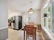Eat-in kitchen area with natural light and a wooden dining table, set against a backdrop of neutral gray walls and tan floors at 7639 Winterset Dr, Charlotte, NC 28270