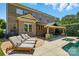 Lounge chairs by a spa are set on a patio outside a brick home with a covered patio and outdoor furniture at 7903 Tottenham Ct, Waxhaw, NC 28173