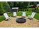 Backyard firepit area with Adirondack chairs, gravel, trampoline and shed surrounded by lush landscaping at 7903 Tottenham Ct, Waxhaw, NC 28173