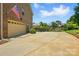 Spacious driveway leading to a garage and backyard with basketball hoop and playhouse, all surrounded by lush greenery at 7903 Tottenham Ct, Waxhaw, NC 28173