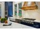 Kitchen with a white marble backsplash, navy blue cabinets, stainless steel range, and a farmhouse sink at 7903 Tottenham Ct, Waxhaw, NC 28173