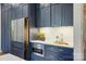 Kitchen features custom navy blue cabinets, stainless refrigerator, and white countertops at 7903 Tottenham Ct, Waxhaw, NC 28173