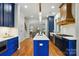 Kitchen with blue cabinets, island, and view of the living room and staircase at 7903 Tottenham Ct, Waxhaw, NC 28173
