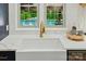 Kitchen features farmhouse sink, gold faucet, white marble countertops and view of pool at 7903 Tottenham Ct, Waxhaw, NC 28173