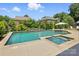 Inviting pool and spa with a stone waterfall feature surrounded by lush greenery at 7903 Tottenham Ct, Waxhaw, NC 28173